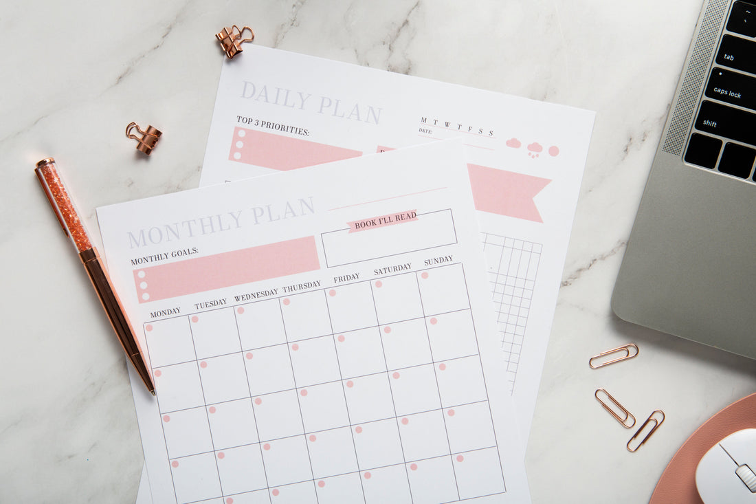 Imagen de un planner 2026 encima de una mesa con un ordenador, unos clips y un bolígrafo alrededor